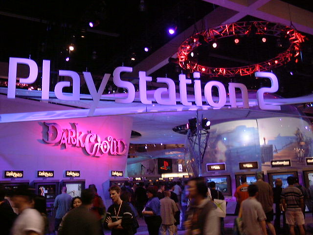 PlayStation 2's Dark Cloud booth — the blue PS2 sign and its colorful RPG companion.