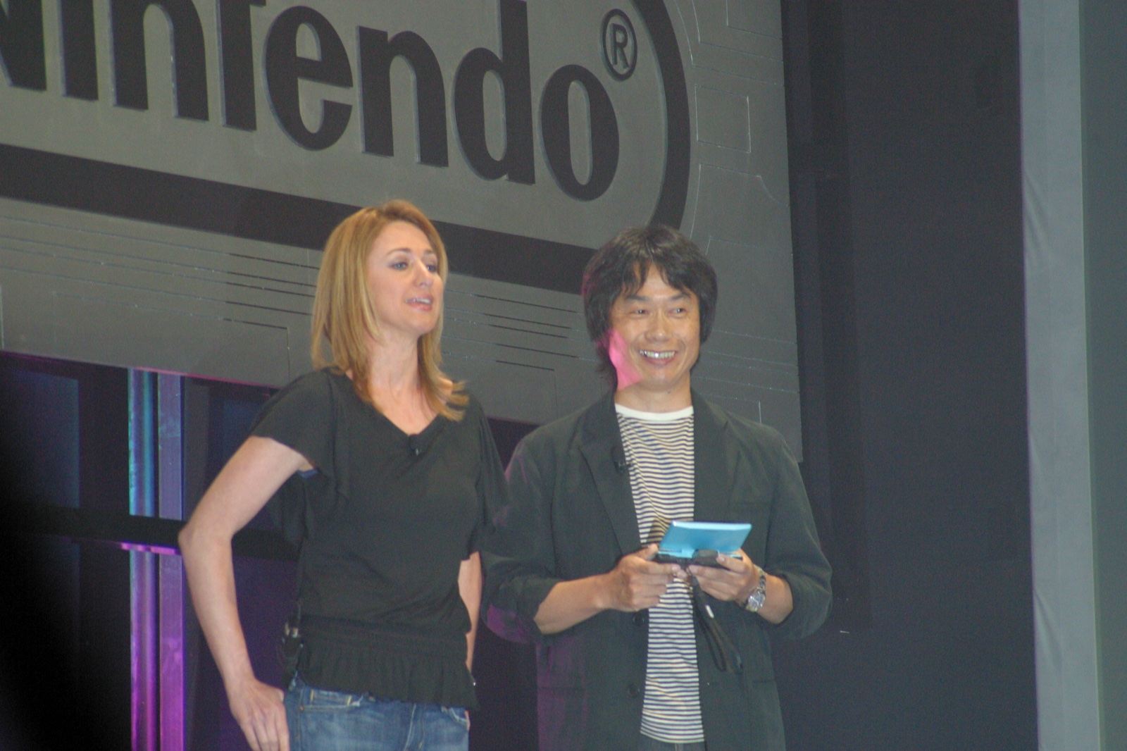 Shigeru Miyamoto on stage at Nintendo's E3 2005 press conference, DS in hand, grinning as always.