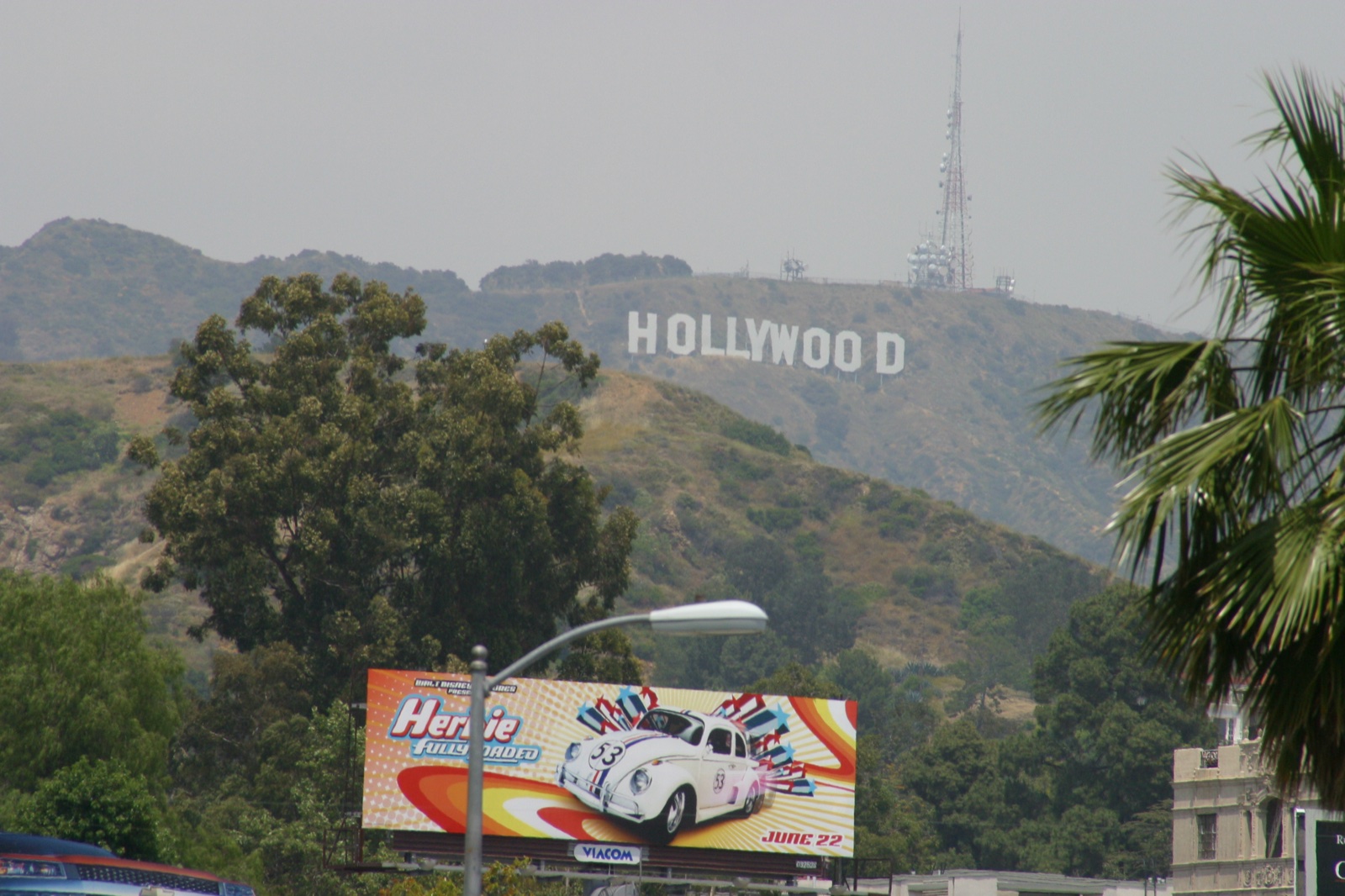 A closer look at the Hollywood sign with a Herbie: Fully Loaded billboard in the foreground — peak mid-2000s LA.