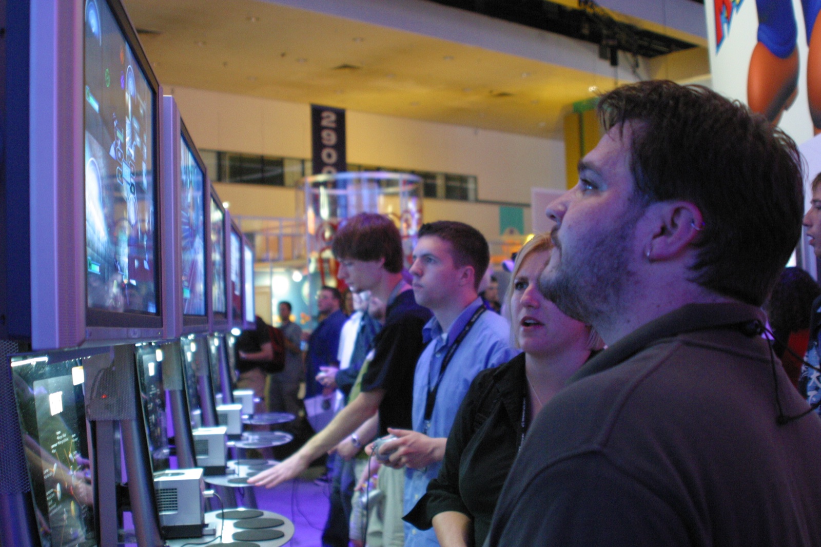 Shawn, Monica, and other attendees lined up at demo stations, controllers in hand — the classic E3 experience.