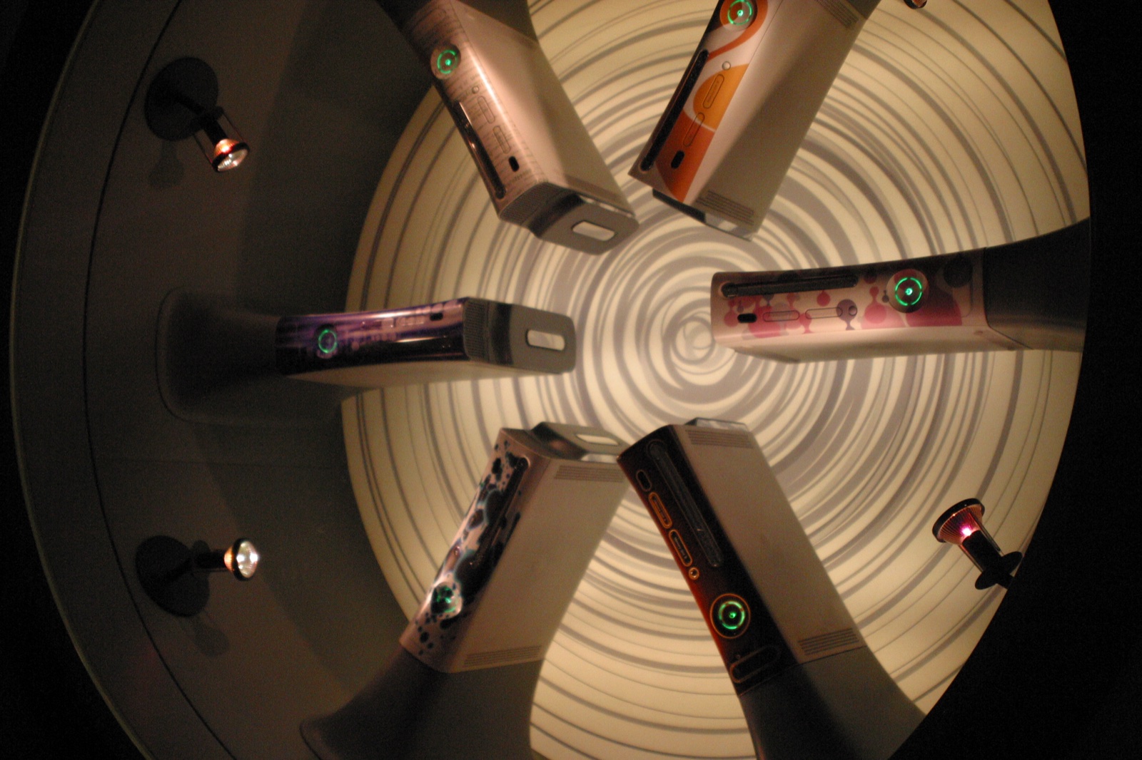 Custom-skinned Xbox 360 consoles arranged in a display case — each one a unique design.