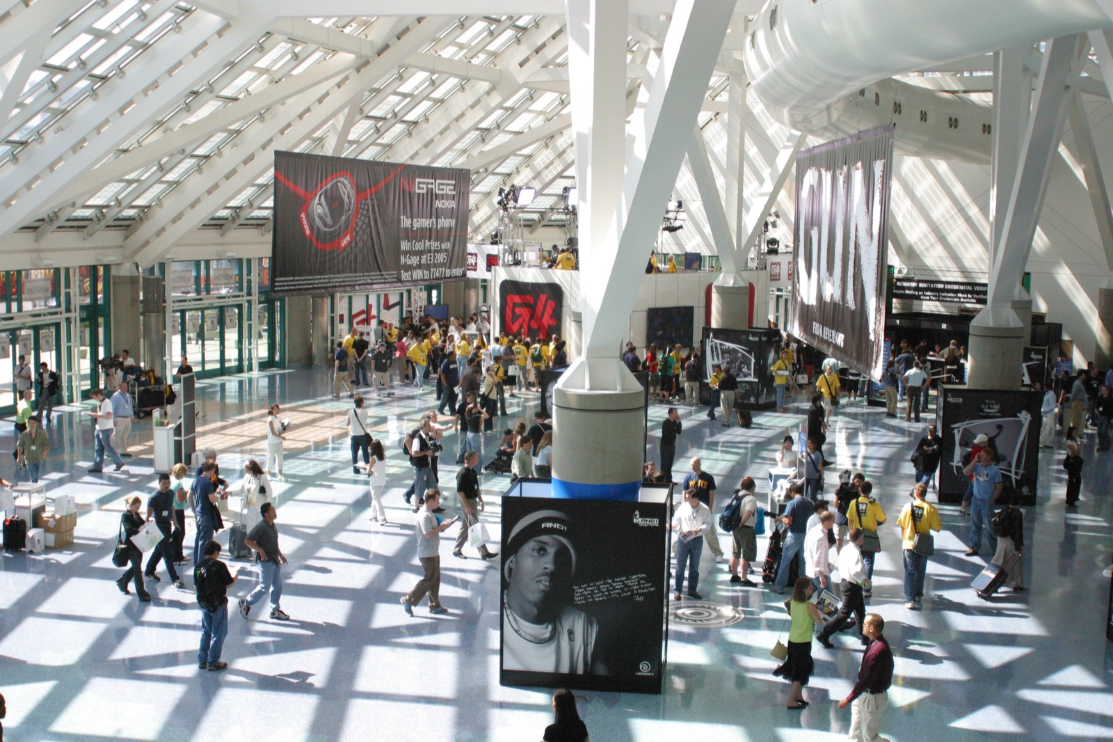 The sun-drenched LACC lobby — GUN, N-Gage, and other game banners hanging from the ceiling.